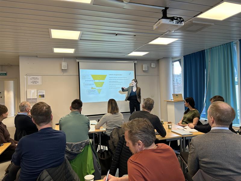 Personer i et møterom ser på ei kvinne som holder en presentasjon. 7. mars var trønderske aktører samla i Trondheim for å diskutere utvikling av lokale energiområder i Trøndelag. Foto: Syver Lie Rønningen.