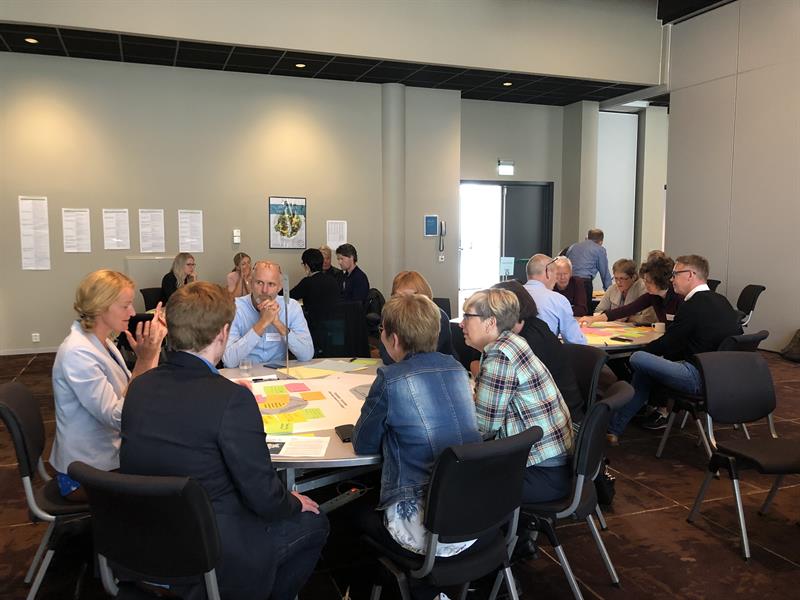 Flere personer sitter rundt bord og diskuterer de ulike innsatsområdene havrommet, opplevelsesnæring og bioøkonomi med forslag til tiltak. Foto: Ida Valsø.