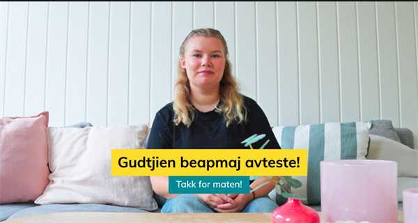 kvinne sitter i en sofa bak et sofabord
