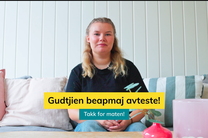 kvinne sitter i en sofa bak et sofabord