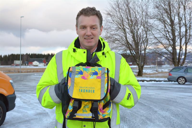 Fylkesvaraordfører Tomas Iver Hallem viser frem skolesekken som alle 1.-klassingene får til høsten (Foto: Mona Jønvik Andersson)