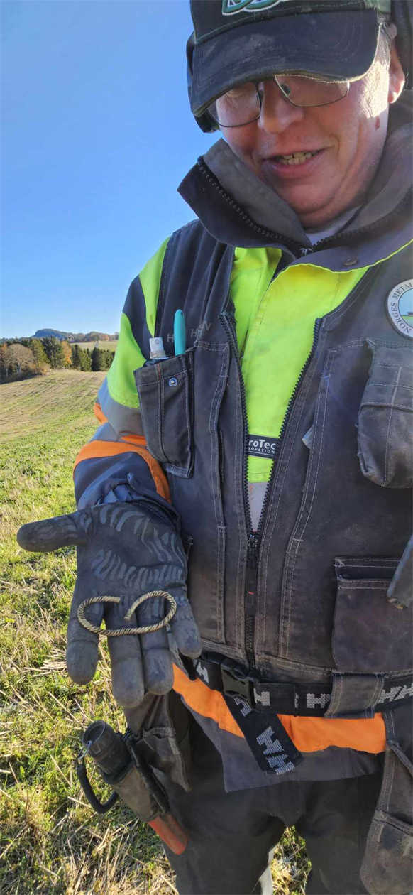 Ingar Karlsen viser frem armbåndet han fant i åkeren. 