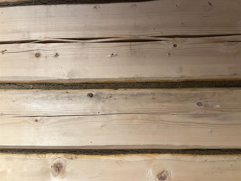 Tømmervegger med fugemasse for brannsikring i mellom.