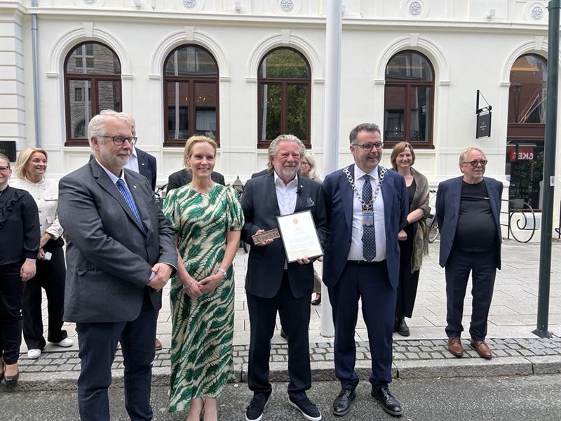 Image (16).jpg Mennesker står oppstilt utenfor Britannia Hotel. Fra venstre fylkesvaraordfører Pål Sæther Eiden, riksantikvar Hanna Geiran, eier Odd Reitan og ordfører Kent Ranum.