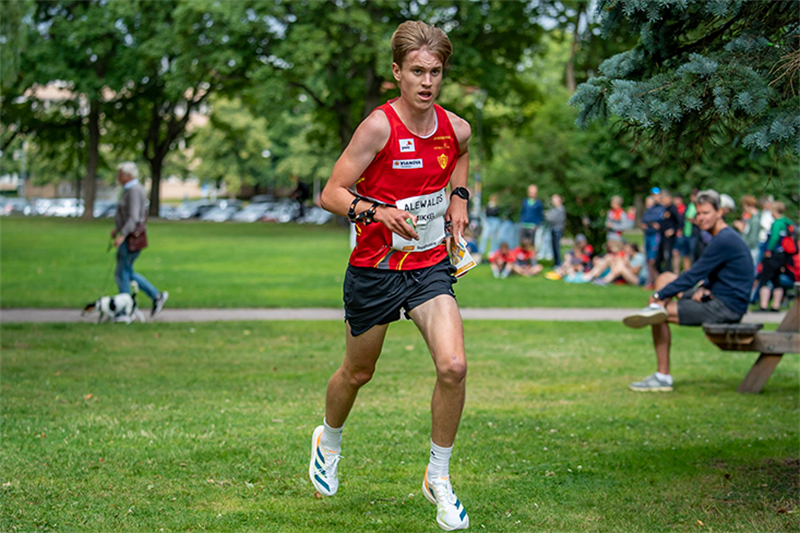 Mikkel Holt løper gjennom en park i en konkurranse. 