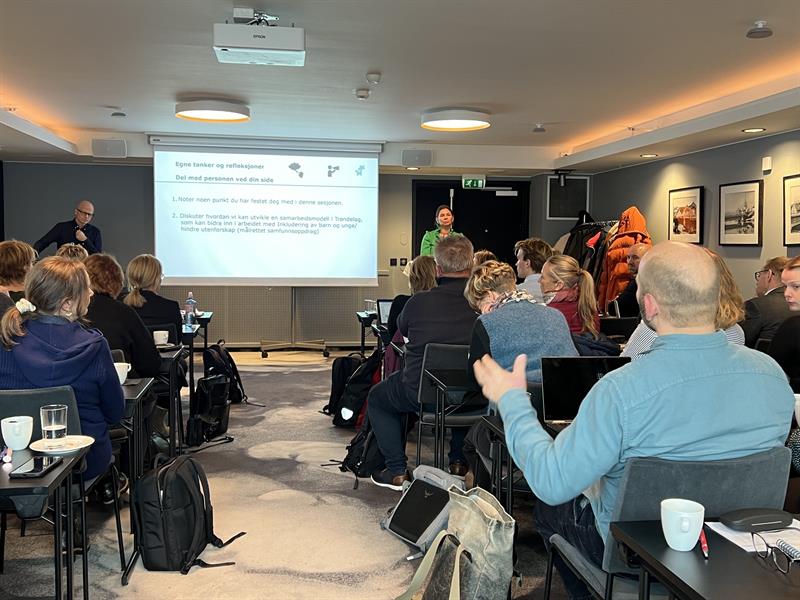 John Tore Vik fra Trøndelag fylkeskommune og Camilla Juul fra KS på scenen. De holdt innlegg om «inkludering av barn og unge». Deltakerne fikk også tid til å diskutere temaene i grupper og i plenum. Foto: Ida Valsø.