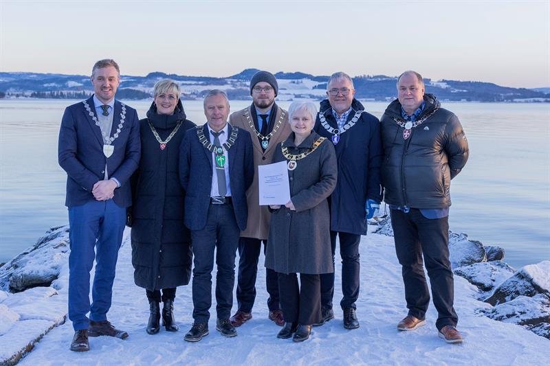 Ordførerne i Innherredsregionen og fylkesordfører Tomas Iver Hallem står ved Trondheimsfjorden. 
