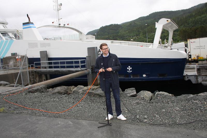 Per Olav Hopsø foretar den symbolske åpningen av ladeanleggene. Foto: Karl-Henrik Linder