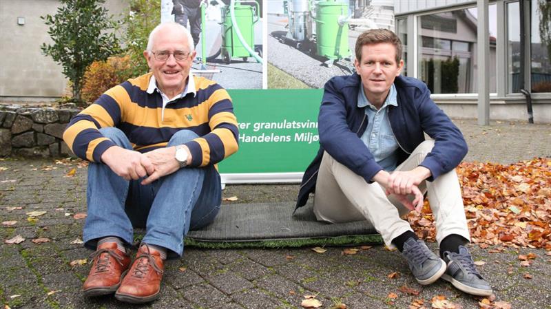 Harald Strand (til venstre) og Ådne Espeland i Green Cleaner sitter på ei sammensydd kunstgrasmatte. Én av ideene de har til gjenbruk av brukt kunstgress. (Foto: Gjesdalbuen / Tore Espedal)