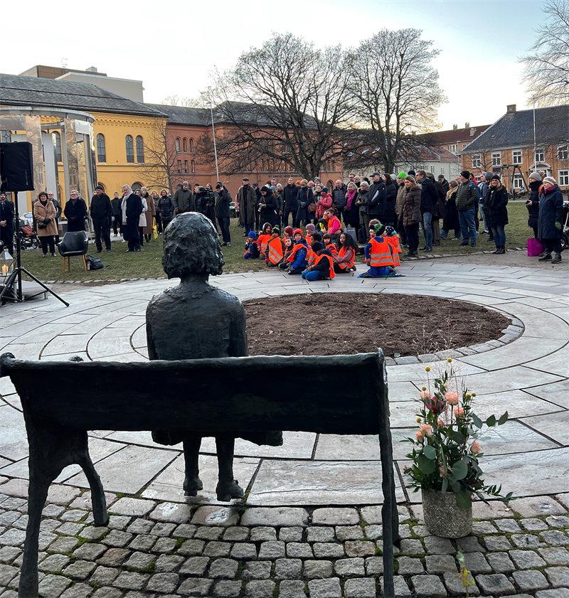 Cissi Klein og publikum_red.png Cissi Klein på benken (statue) med publikum på fredningsserremonien foran seg.