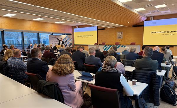 Fylkesordfører Tomas Iver Hallem står bak prekestolen og snakker til et publikum på rundt 45 personer i Fylkestingssalen.