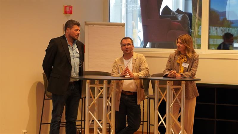 Lars Ahlin, Lars Peder Haga og Guro A. Gimse står ved siden av hverandre. Foran seg har de to rundbord.