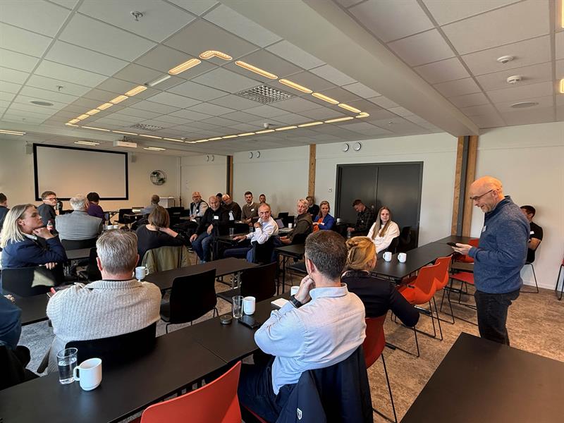 Arne Martin Solli står oppreist og snakker til en samling mennesker som sitter på stoler rundt og lytter til ham. Foto: Ida Valsø, Trøndelag fylkeskommune.